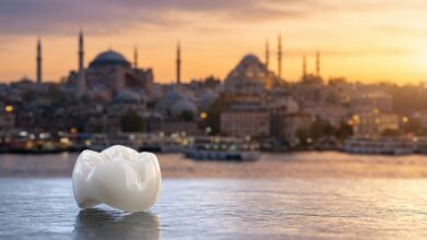 A photorealistic close-up of a single, perfect dental implant crown on a clean surface, with the beautiful, blurred skyline of Istanbul, Turkey, during sunrise in the background, symbolizing a dental tourism holiday.