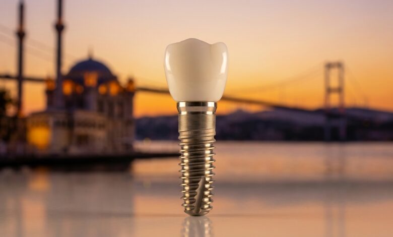 A photorealistic macro photograph of a single, high-quality dental implant and crown. The background is a soft, out-of-focus view of the Istanbul, Turkey skyline over the Bosphorus during a warm sunset.