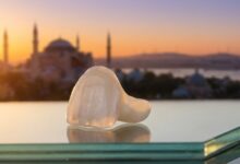 A photorealistic close-up of a perfect porcelain dental veneer, with the iconic skyline of Istanbul, Turkey, beautifully blurred in the background during a warm sunrise, symbolizing a dental vacation.