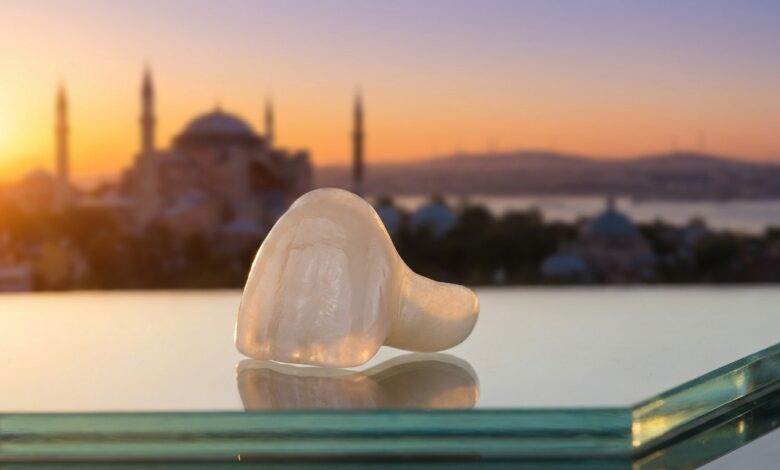 A photorealistic close-up of a perfect porcelain dental veneer, with the iconic skyline of Istanbul, Turkey, beautifully blurred in the background during a warm sunrise, symbolizing a dental vacation.