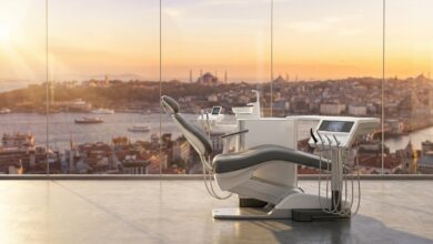A photorealistic view from inside a modern, empty dental clinic looking out a large window at a beautiful, blurred sunrise over the Istanbul, Turkey skyline, symbolizing the concept of dental tourism.