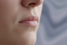Close-up of a person's jaw and mouth area, showing subtle tension and clenching, with a blurred, abstract background symbolizing psychological stress. The image illustrates the physical impact of stress on oral health.