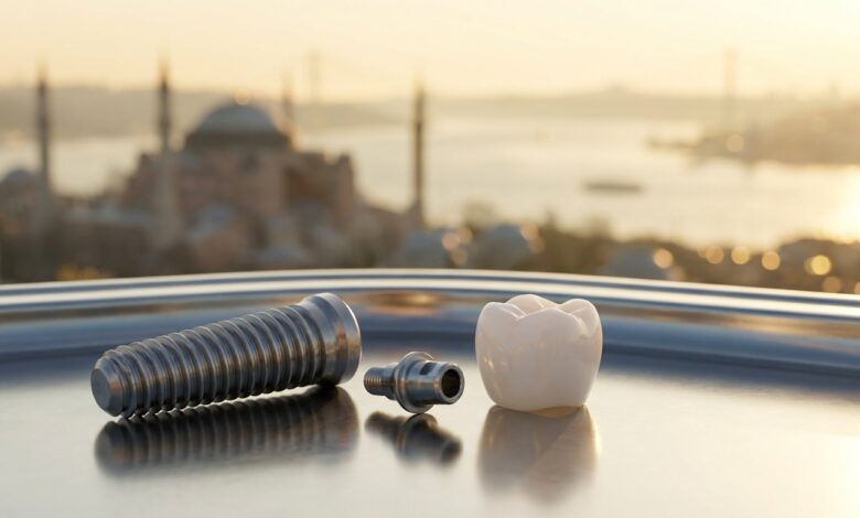 A close-up, photorealistic image showing a titanium dental implant post, an abutment, and a ceramic crown laid out on a clean surface. In the background, the Istanbul, Turkey skyline is softly blurred, creating a beautiful bokeh effect at sunrise.