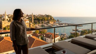 A photorealistic image from a high-rise balcony showing a person with a happy smile looking out over a beautiful Turkish coastal city at sunset, symbolizing a successful dental tourism trip.