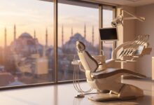 A pristine, modern dental clinic room with an empty treatment chair in the foreground. Through a large window, the background shows a softly blurred, iconic sunrise view of the Istanbul, Turkey skyline.