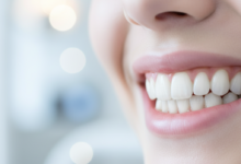 Close-up of a perfectly aligned, bright, white, and healthy human smile with natural looking teeth, against a softly blurred, clean, modern background.