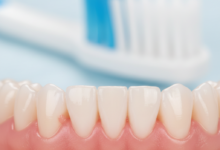 Close-up photorealistic image of healthy pink gums and white teeth, with a blurred soft-bristled toothbrush head in the background, symbolizing oral hygiene and gum disease prevention.