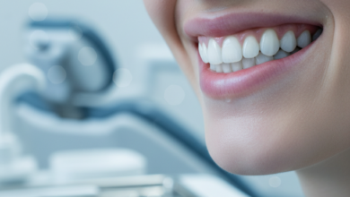 Close-up of a person's mouth displaying a wide, confident smile with exceptionally bright, white, and perfectly aligned teeth. The background is a soft, out-of-focus view of a clean, modern dental clinic.