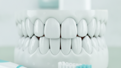 Close-up of perfectly clean, white, healthy teeth in a bright, hygienic setting. A blurred soft-bristled toothbrush and dental floss are visible in the background.