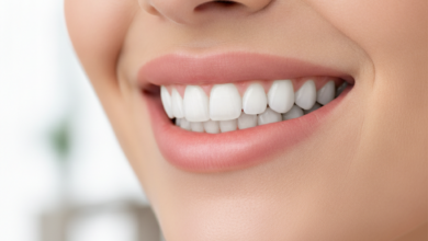 A close-up, photorealistic image of a person's mouth with perfectly white, aligned, and symmetrical teeth, representing a 'Hollywood Smile,' set against a softly blurred, clean, modern background.